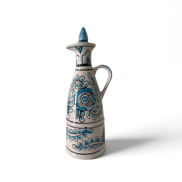 Blue and white ceramic decorative bottle with intricate floral patterns, a curved handle and matching stopper on a white background.